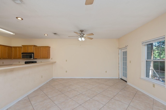 647 Gap Creek Dr, Fort Walton Beach, FL 32548 - kitchen with stainless steel microwave, ceiling fan, brown cabinets, recessed lighting, and light countertops