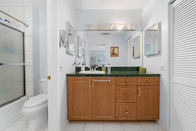 bathroom with toilet, tile patterned flooring, vanity, and baseboards