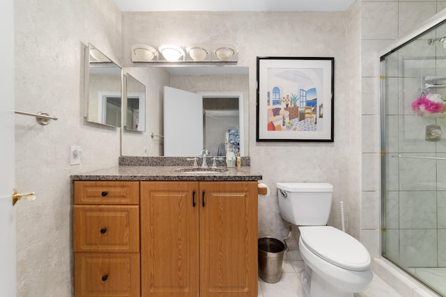 bathroom with a shower stall, toilet, vanity, and tile patterned flooring