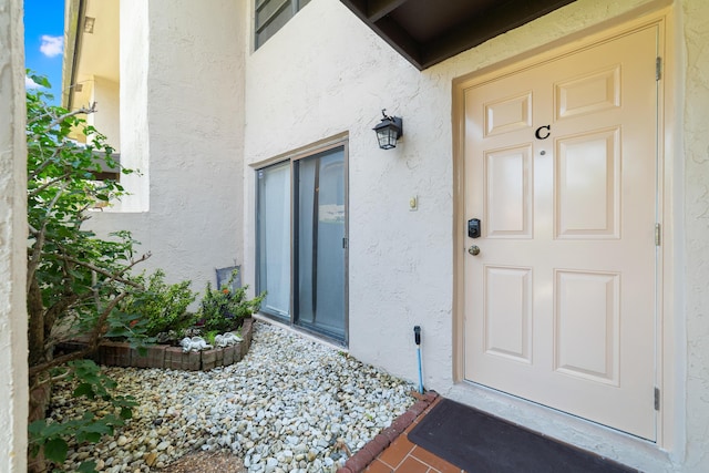 doorway to property featuring stucco siding