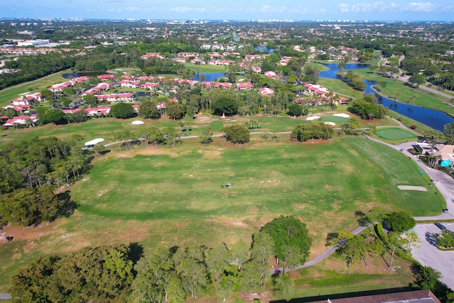 aerial view of property's location featuring a nearby body of water, a golf course, and nearby suburban area