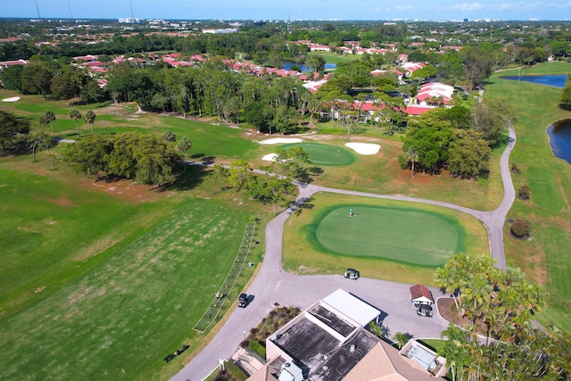 aerial view of property and surrounding area featuring a large body of water, a tree filled landscape, and a local golf course