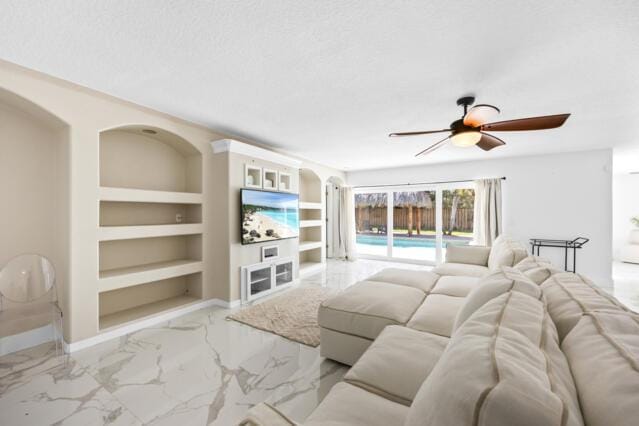 living area with marble finish floor, built in features, baseboards, ceiling fan, and a textured ceiling