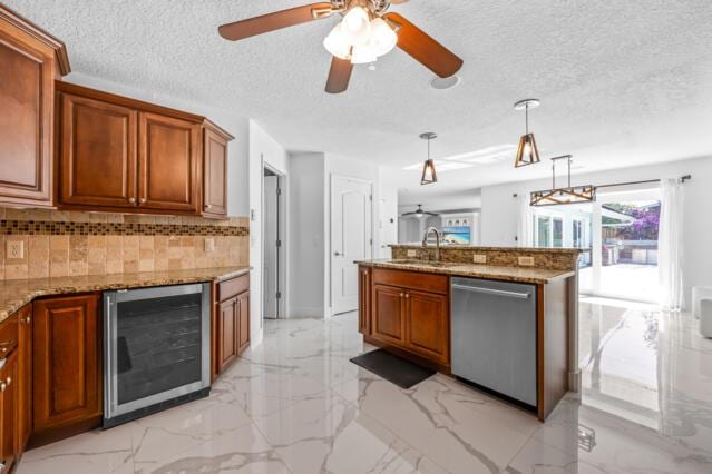 kitchen featuring marble finish floor, brown cabinets, beverage cooler, and dishwasher