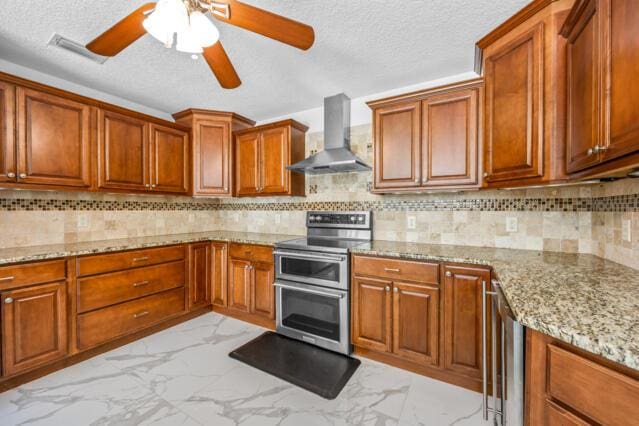 kitchen with marble finish floor, brown cabinets, range hood, and range with two ovens