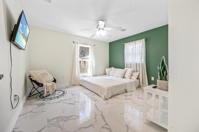 bedroom with a ceiling fan and marble finish floor