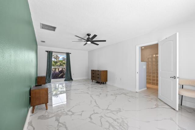 unfurnished living room featuring ceiling fan, visible vents, baseboards, and marble finish floor