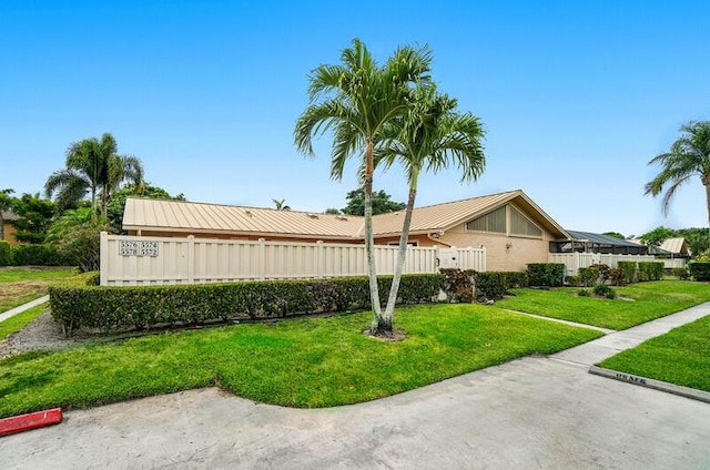 5578 Golden Eagle Cir Unit 5578, Palm Beach Gardens, FL 33418 - view of front of house featuring metal roof, fence, and a front yard