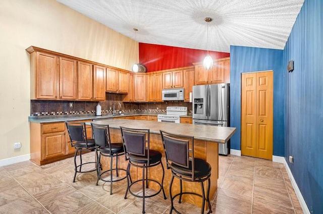 5578 Golden Eagle Cir Unit 5578, Palm Beach Gardens, FL 33418 - kitchen featuring a kitchen island, decorative backsplash, high vaulted ceiling, and white appliances