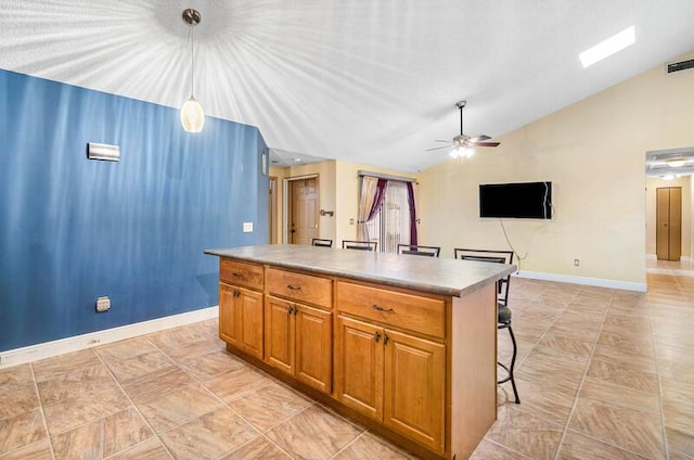 5578 Golden Eagle Cir Unit 5578, Palm Beach Gardens, FL 33418 - kitchen featuring lofted ceiling, baseboards, a kitchen bar, a ceiling fan, and a kitchen island