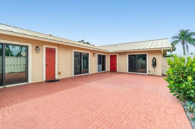 5578 Golden Eagle Cir Unit 5578, Palm Beach Gardens, FL 33418 - back of house featuring a patio, brick siding, metal roof, and a standing seam roof