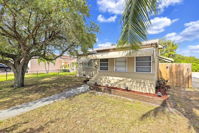view of front of home featuring a front lawn and fence