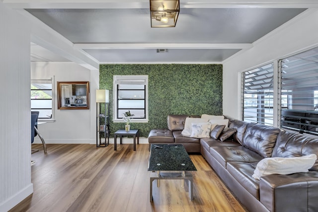 living room with visible vents, wood finished floors, an accent wall, baseboards, and wallpapered walls