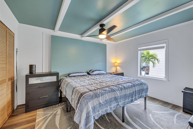 bedroom with beamed ceiling, a ceiling fan, baseboards, and wood finished floors