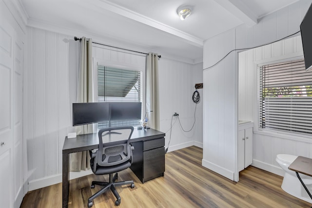 office space featuring light wood-type flooring, plenty of natural light, and beamed ceiling