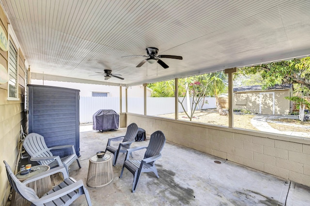 sunroom / solarium featuring a ceiling fan