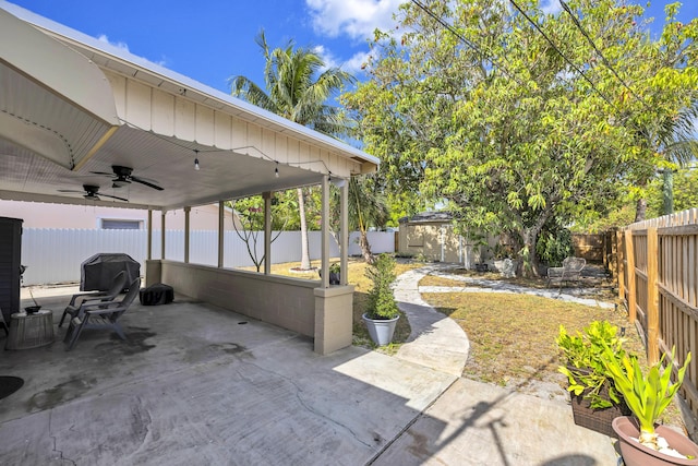 view of patio featuring a ceiling fan, a fenced backyard, and an outbuilding