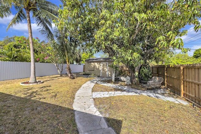 view of yard with a fenced backyard and an outbuilding