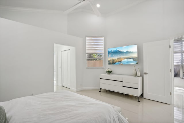 bedroom featuring baseboards, multiple windows, ornamental molding, and a towering ceiling