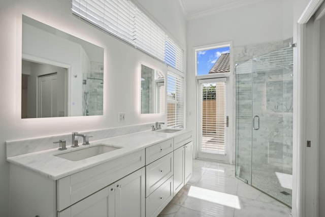 bathroom with a sink, crown molding, a shower stall, and double vanity