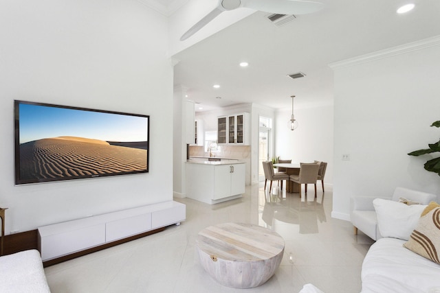 living room with crown molding, a ceiling fan, visible vents, and recessed lighting