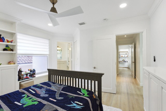 bedroom featuring a ceiling fan, visible vents, crown molding, light wood-style floors, and ensuite bathroom