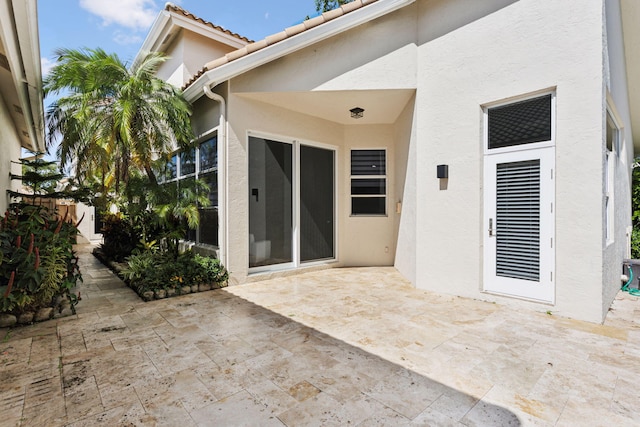 exterior space featuring a patio, stucco siding, and a tile roof