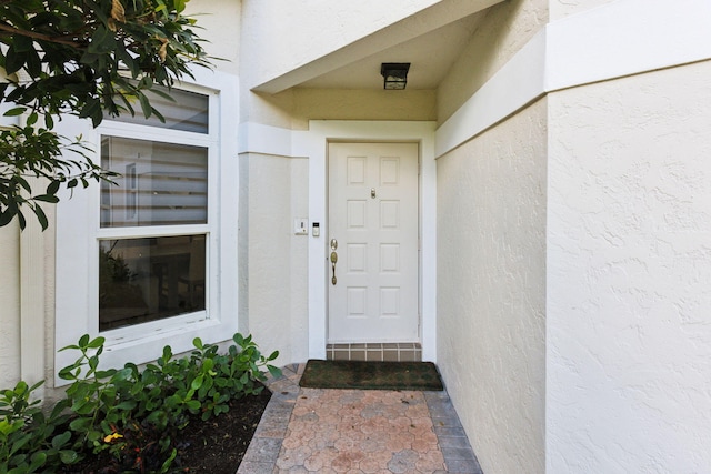 entrance to property featuring stucco siding