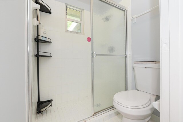 bathroom with a shower stall and toilet