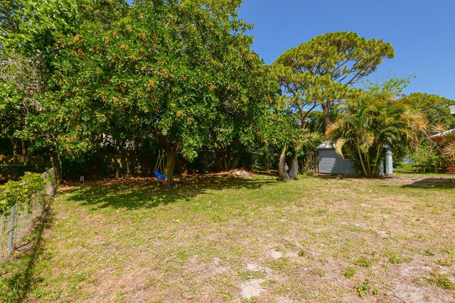 view of yard with fence and an outbuilding