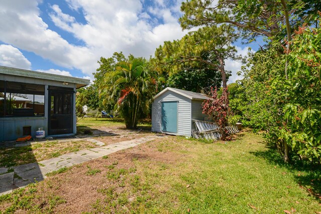 view of yard with an outbuilding, a shed, and a sunroom