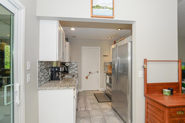 kitchen featuring backsplash, appliances with stainless steel finishes, light tile patterned floors, white cabinets, and recessed lighting