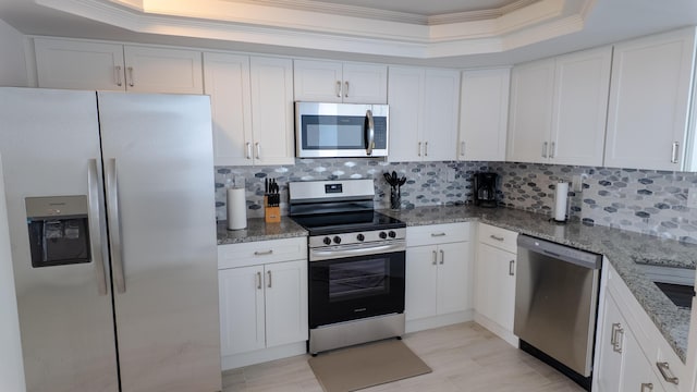 9500 S Ocean Dr Unit 1502, Jensen Beach, FL 34957 - kitchen featuring stainless steel appliances, a tray ceiling, crown molding, decorative backsplash, and light stone counters