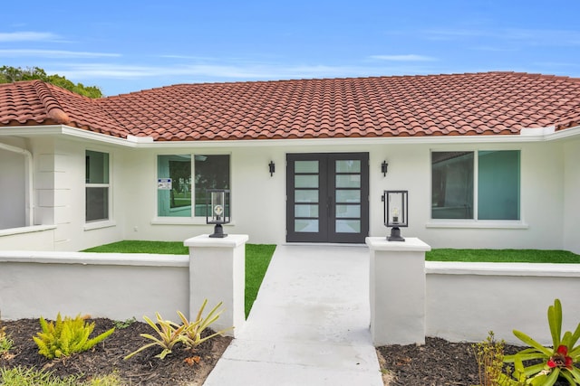 4372 SW Bimini Cir N, Palm City, FL 34990 - property entrance featuring stucco siding, a tiled roof, and french doors
