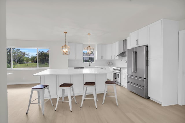 4372 SW Bimini Cir N, Palm City, FL 34990 - kitchen with high quality appliances, wall chimney exhaust hood, a sink, and a breakfast bar