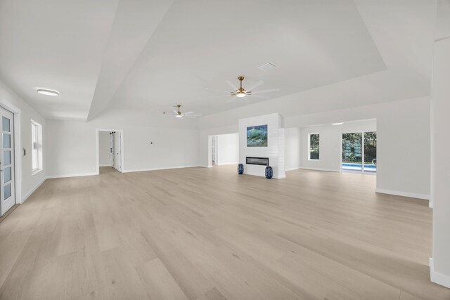 4372 SW Bimini Cir N, Palm City, FL 34990 - unfurnished living room featuring a large fireplace, baseboards, light wood finished floors, and ceiling fan