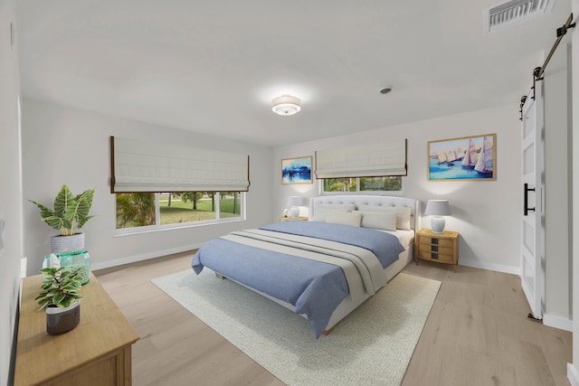 4372 SW Bimini Cir N, Palm City, FL 34990 - bedroom featuring a barn door, baseboards, and light wood-type flooring