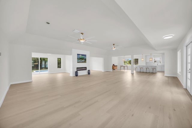 4372 SW Bimini Cir N, Palm City, FL 34990 - unfurnished living room with a ceiling fan, a fireplace, baseboards, and light wood finished floors