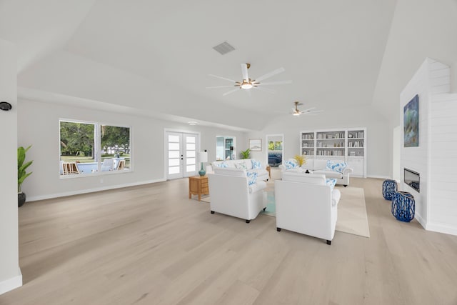 4372 SW Bimini Cir N, Palm City, FL 34990 - living room with light wood-style flooring, vaulted ceiling, a ceiling fan, french doors, and a large fireplace