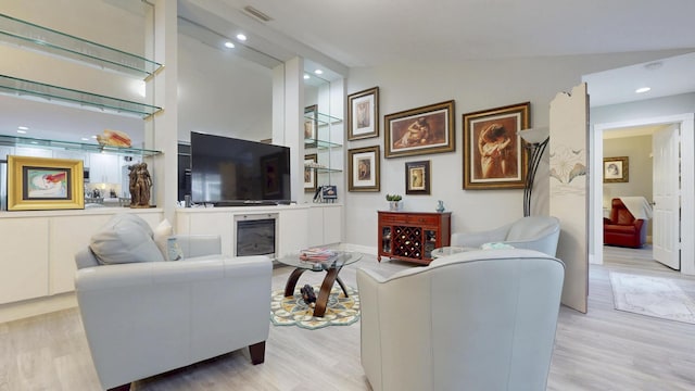 living room with visible vents, recessed lighting, wood finished floors, and lofted ceiling