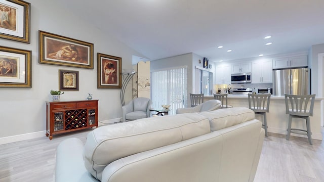 living room featuring light wood-type flooring, recessed lighting, and baseboards