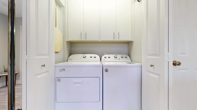 laundry room featuring independent washer and dryer and cabinet space