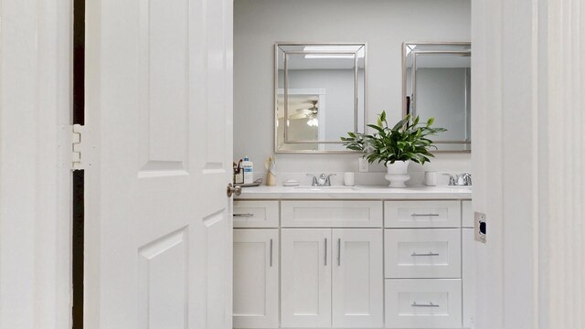 full bath featuring double vanity, a sink, and a tile shower