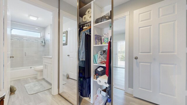 corridor featuring baseboards and wood finished floors