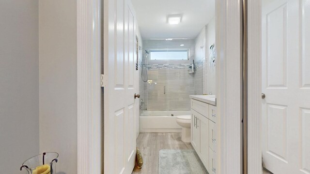 full bathroom with toilet, enclosed tub / shower combo, and vanity