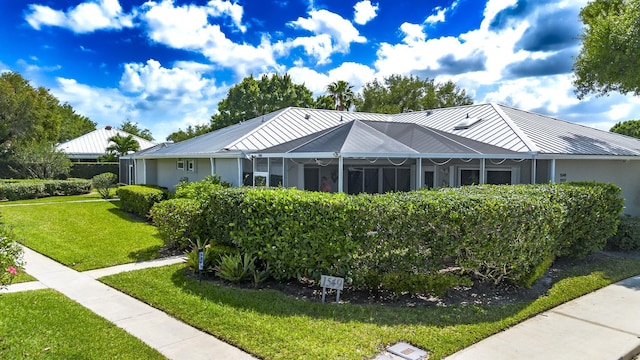 view of front of home featuring metal roof and a front lawn