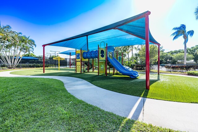 communal playground featuring fence and a yard