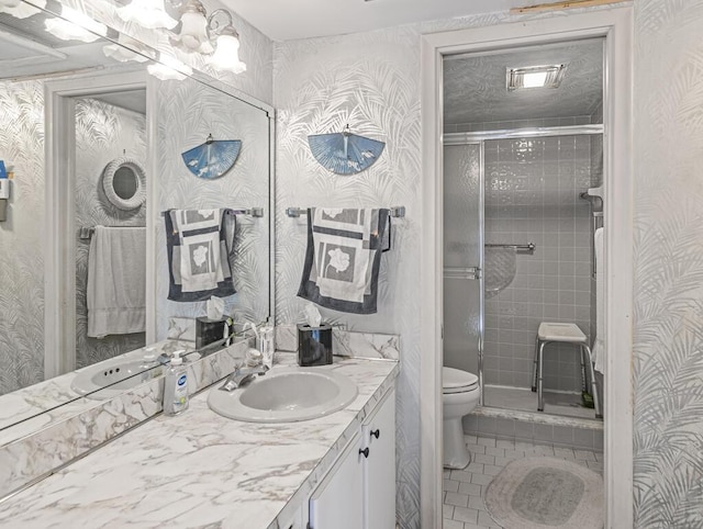 103 Oxford 500 Unit 103, West Palm Beach, FL 33417 - bathroom with toilet, vanity, a stall shower, tile patterned flooring, and wallpapered walls