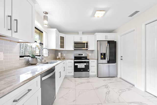 4670 Laurel Tree Rd Unit A, Boynton Beach, FL 33436 - kitchen with light stone countertops, visible vents, a sink, white cabinets, and appliances with stainless steel finishes