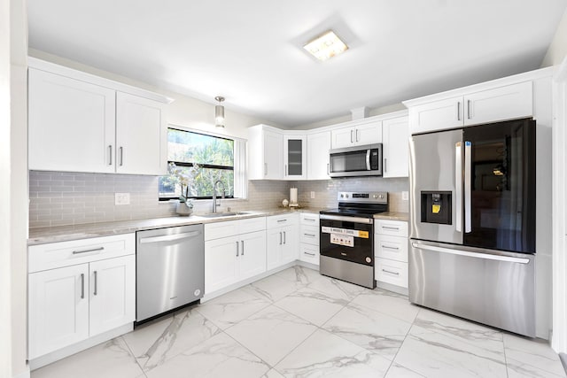 4670 Laurel Tree Rd Unit A, Boynton Beach, FL 33436 - kitchen featuring marble finish floor, light stone counters, a sink, white cabinets, and appliances with stainless steel finishes